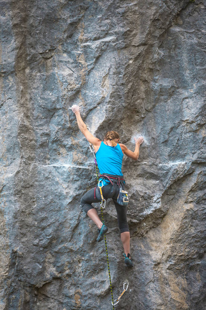 Le grimpeur s'entraîne à escalader le rocher. Une fille forte surmonte une route d'escalade difficile. Mode de vie actif. Un passe-temps extrême. Une femme va faire du sport dans la nature
. - Photo, image