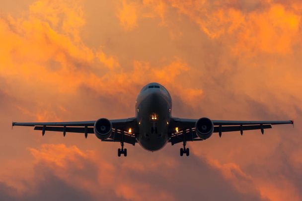 Αεροδρόμιο προσγείωση σιλουέτα αεροπλάνο το απόγευμα στο ηλιοβασίλεμα, τον ουρανό και τη γραφική σύννεφα - Φωτογραφία, εικόνα