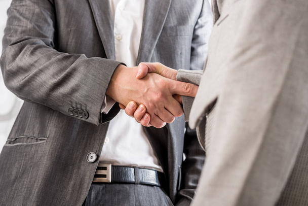 Closeup of business man and woman shaking hands in agreement. - Photo, image
