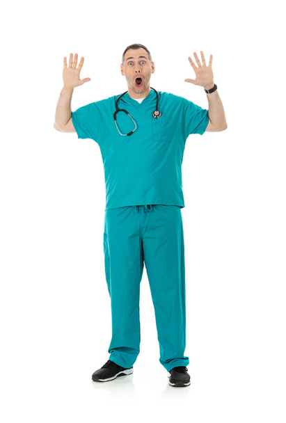 Humorous male doctor in scrubs in a variety of poses on a white isolated background. Scared man with hands raised. - Photo, Image