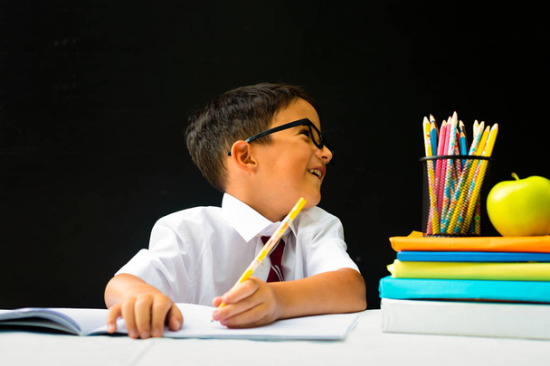 Pré-escola inteligente ou menino da escola de primeiro grau em camisa branca com óculos de olho distraído
 - Foto, Imagem
