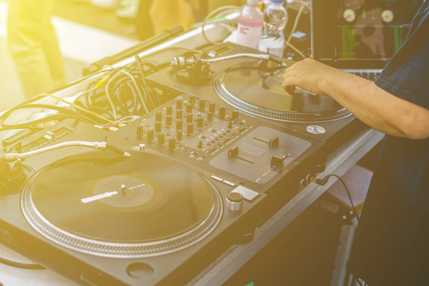 dj manos reproducir vibraciones de música en una fiesta de verano en la playa utilizando una plataforma vintage configuración tocadiscos
 - Foto, imagen