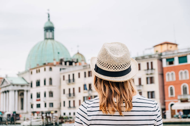 Dziewczynka stoi z ją z powrotem i patrzy na piękny widok miasta Europejskiego w lecie. - Zdjęcie, obraz