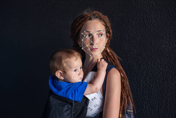 Verificación biométrica. Joven mujer moderna con un bebé. El concepto de una nueva tecnología de reconocimiento facial en la red poligonal está construido por los puntos de seguridad y protección de TI
 - Foto, imagen