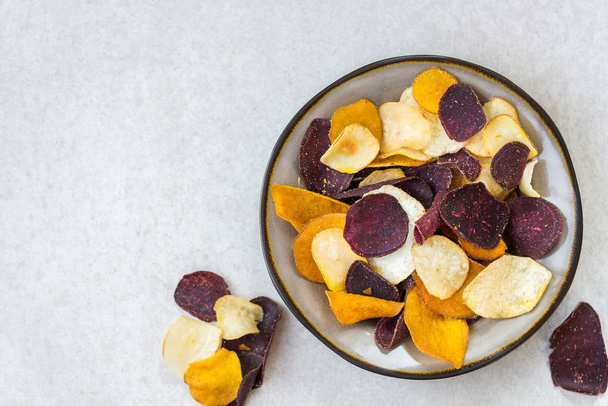 A növényi chip, mint például az édes burgonya, cékla, sárgarépa, pasztinák, világos szürke háttér egészséges Snack tál - Fotó, kép