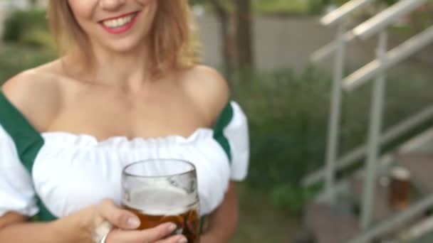 Uma linda loira sorri e segura um copo de cerveja alemã no festival de cerveja Oktoberfest, na Alemanha
 - Filmagem, Vídeo