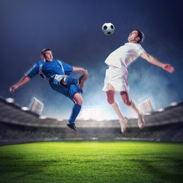 two football players striking the ball - Foto, afbeelding