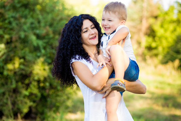 Portrait of happy mother and son smiling outdoors - Foto, imagen