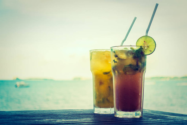 Ice mojito drinking glass with tropical sea ocean and beach view - Foto, imagen