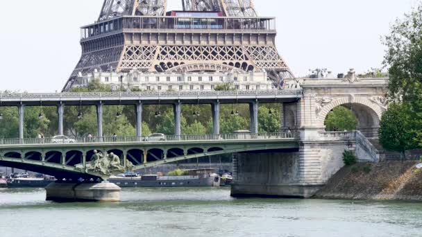 die bir-hakeim-Brücke ist eine berühmte Pariser Brücke, die manchmal als Filmkulisse genutzt wird. Dahinter befindet sich die erste Etage des Eiffelturms. Eine U-Bahn fährt über die Brücke. Mit langer Brennweite gefilmt. - Filmmaterial, Video