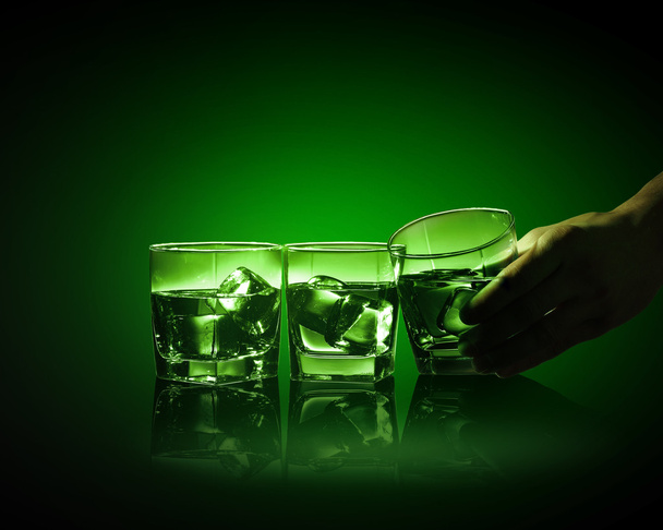 Three glasses of green absinth with ice cubes - 写真・画像