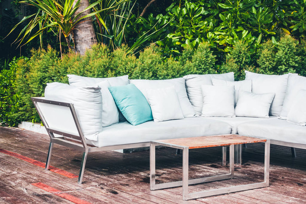 Удобная подушка для украшения дивана на открытом патио с тропическим и природным видом
 - Фото, изображение