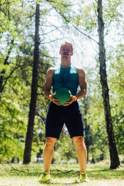 Jovem saudável exercitando com bola de medecina na natureza
 - Foto, Imagem