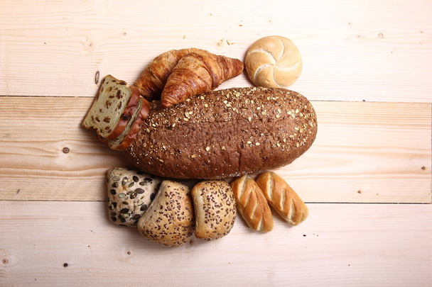Set of different loaves on wooden background - Fotó, kép
