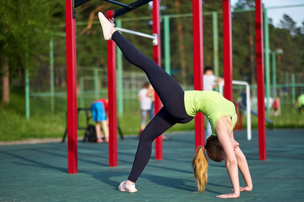 Stretching fit or dancer woman doing exercise in workout sports ground. - Photo, Image