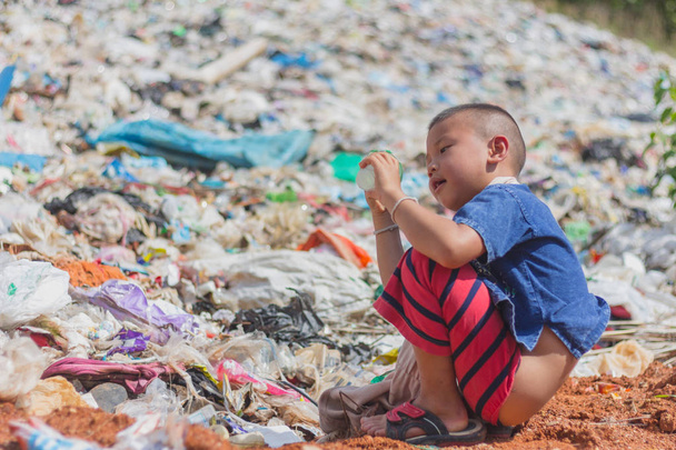 Дети находят мусор для продажи и перерабатывают его на свалках, жизни и образе жизни бедных, концепции бедности, детского труда и торговли людьми
. - Фото, изображение