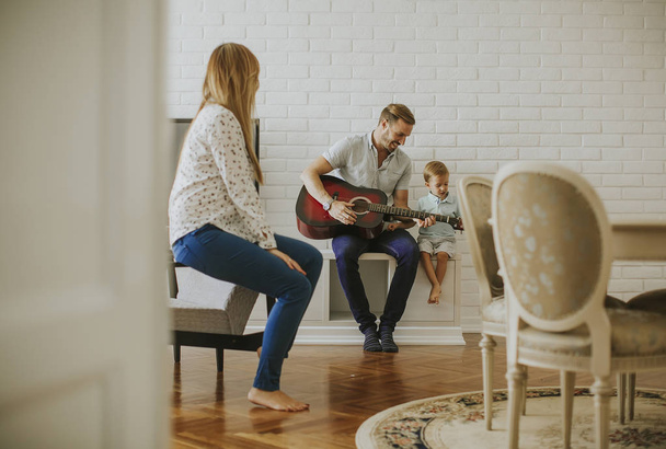 Happy family with guitar at home - Zdjęcie, obraz