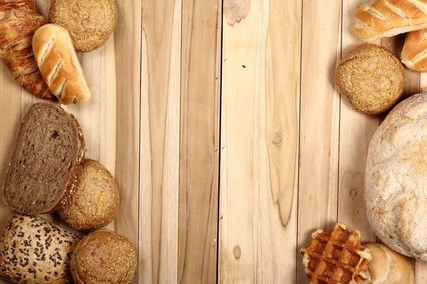 Set of different loaves on wooden background - Foto, afbeelding