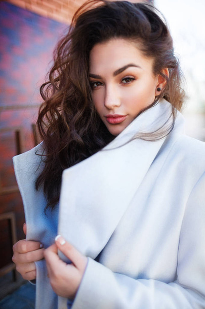 Beautiful young woman in white coat posing - Foto, immagini