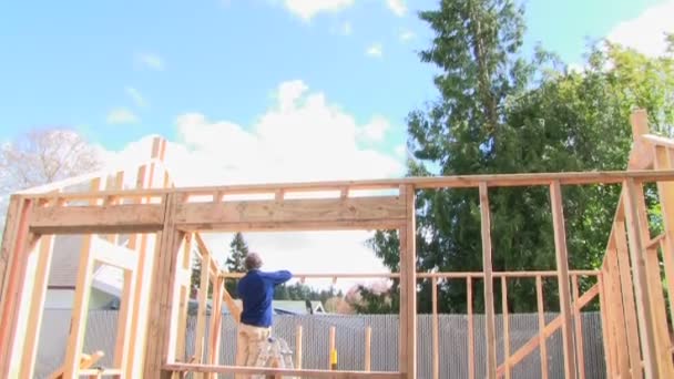 muž staví dřevěný dům - Záběry, video