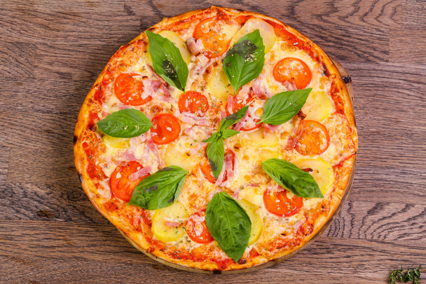 Pizza z szynką i ziemniaczane serwowane bazylia - Zdjęcie, obraz