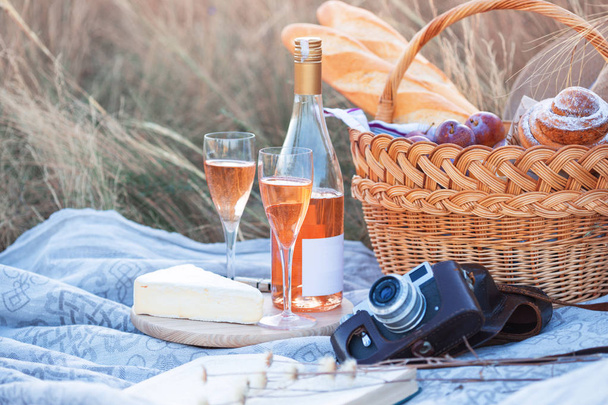 Summer - Provencal picnic in the meadow.  baguette, wine, glasses, grapes, Cheese brie, baguette in a basket - Foto, imagen