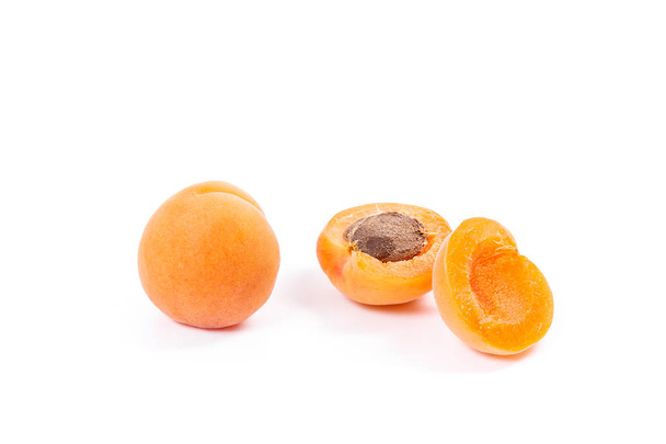 Close up view of ripe whole and halved apricots isolated on white background. Healthy food concept. Harvest time - Zdjęcie, obraz