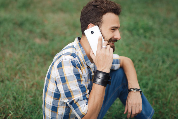 Attractive young bearded hipster with mobile phone. Bearded man talking on mobile phone. - Foto, Imagem