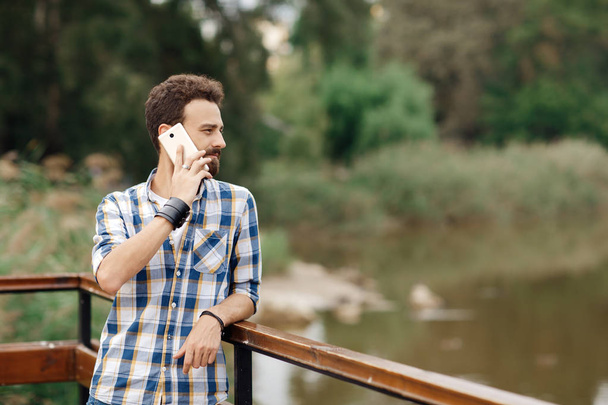 Attractive young bearded hipster with mobile phone. Bearded man talking on mobile phone. - Φωτογραφία, εικόνα