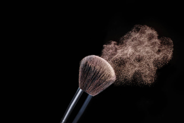 Make up brush with powder splashes on black background - Фото, зображення