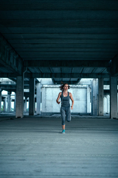 athlete woman running in abandoned building - Фото, зображення