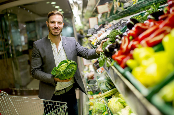Young man buying vegetables in the supermarket - Foto, Imagem