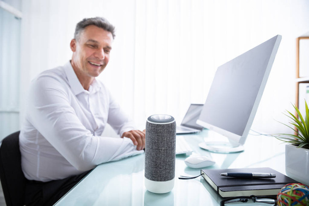 Smiling Mature Man Listening To Music On Wireless Speaker - Valokuva, kuva