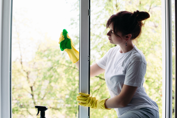 Černovlásky hospodyňka čištění velké špinavé okno. Koncepce domácí práce a byt služby. - Fotografie, Obrázek