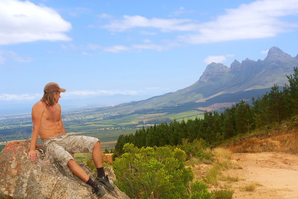 Young man looks at mountains - Foto, afbeelding