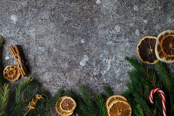 Χριστούγεννα ή Πρωτοχρονιά επίπεδη θέσει, ξηρό πορτοκάλια, κανέλα, καραμέλα και έλατα κλαδιά - Φωτογραφία, εικόνα