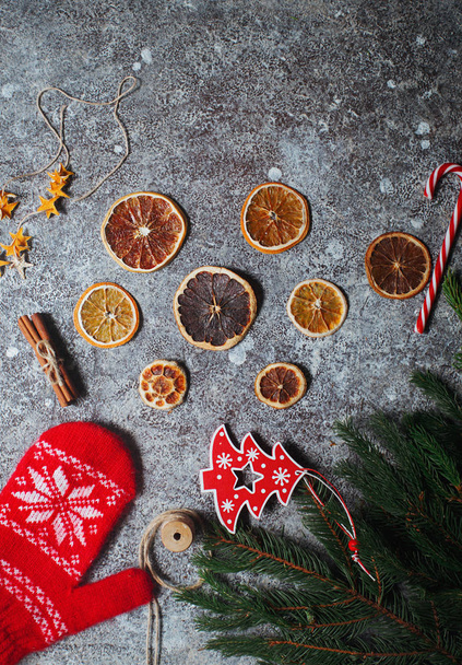 Christmas flat lay with dry oranges, cinnamon, fir branches and glove - Фото, зображення