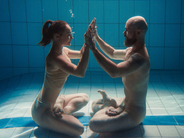 Ritratto subacqueo della coppia di asana di yoga (uomo e donna) in piscina
 - Foto, immagini
