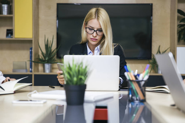 Dość młoda blond kobieta działa na laptopie w biurze - Zdjęcie, obraz