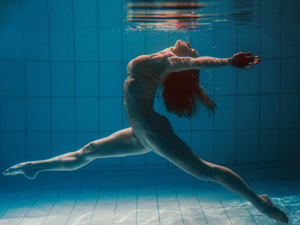 Αθλητική σπορ γυναίκα κάτω από το νερό στην πισίνα - Φωτογραφία, εικόνα