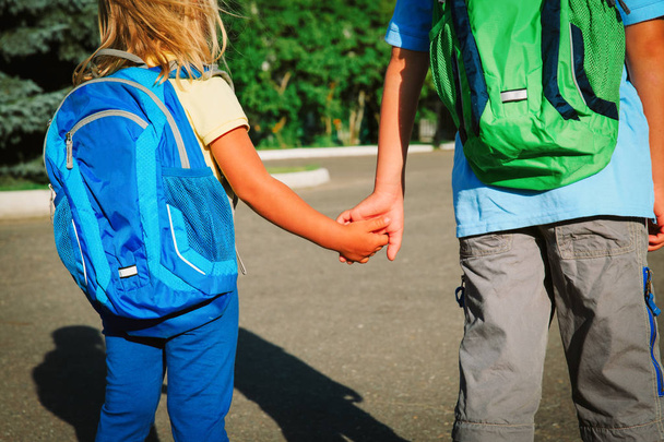 kleine jongen en meisje hand in hand gaan naar school - Foto, afbeelding