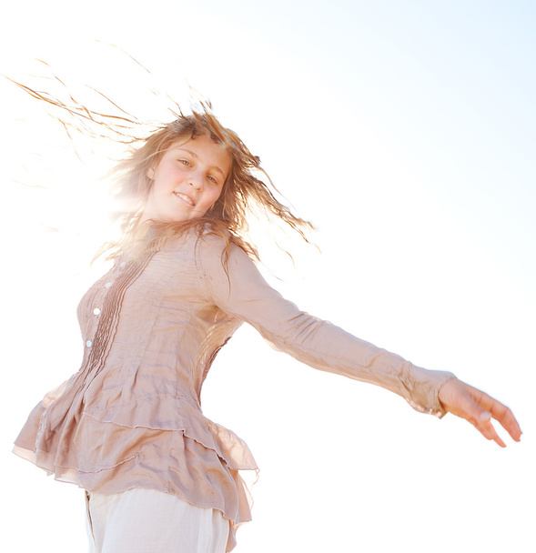 Молодая блондинка машет волосами в воздухе солнечными лучами, фильтруя их и улыбаясь
. - Фото, изображение
