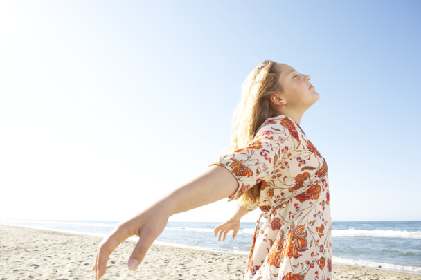 κορίτσι ο αναπνέοντας καθαρός αέρας, στεμένος από την ακτή σε μια παραλία με λευκή άμμο. - Φωτογραφία, εικόνα