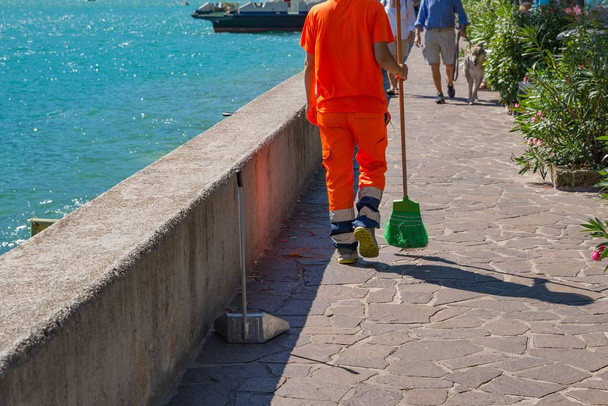 Travailleur des services de nettoyage de la ville en uniforme réfléchissant balayant la rue
 - Photo, image