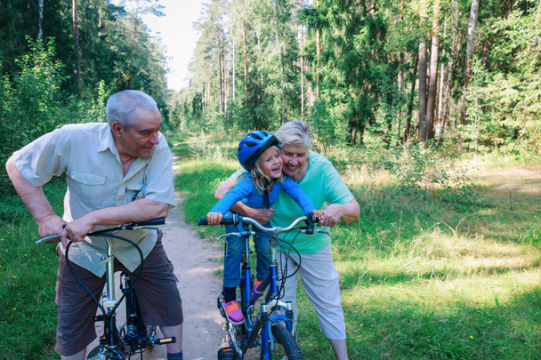 активна старша пара з маленькою онучкою на велосипедах у природі
 - Фото, зображення
