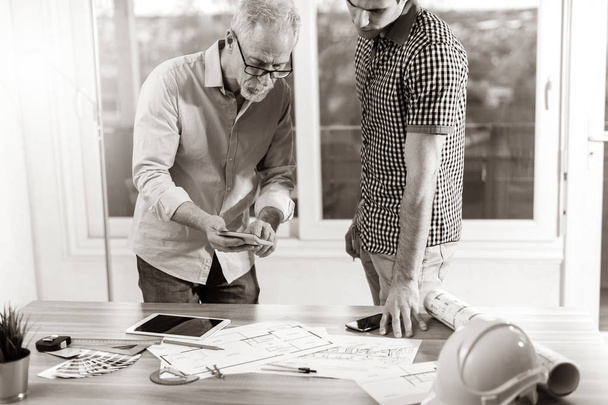 Architects working on plans at office, black and white - Photo, Image