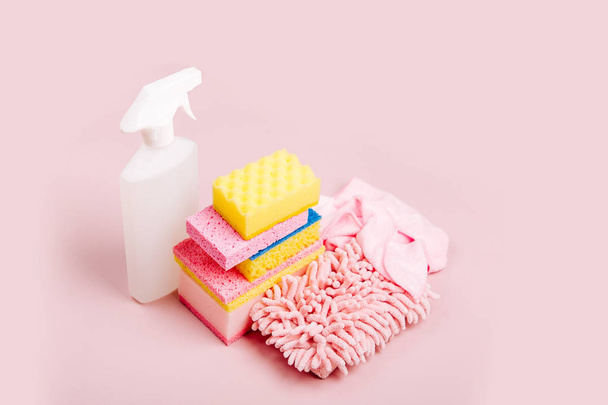 Tisztító spray, szivacsok, mikroszálas kendő és a kesztyűt a rózsaszín háttér - Fotó, kép