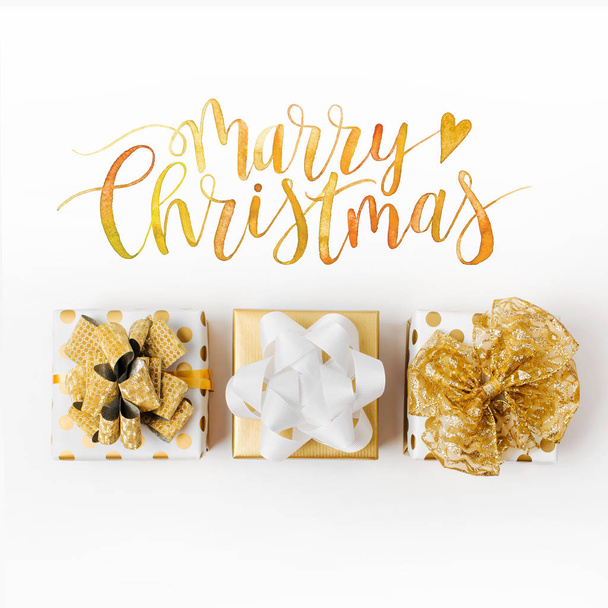 top view of gift boxes and golden marry christmas lettering isolated on white background  - Foto, Imagem