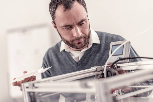 Smart adult engineer fixing a 3D printer - Foto, Imagen