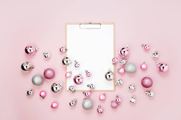top view of clipboard with empty paper sheet and christmas baubles - Fotó, kép
